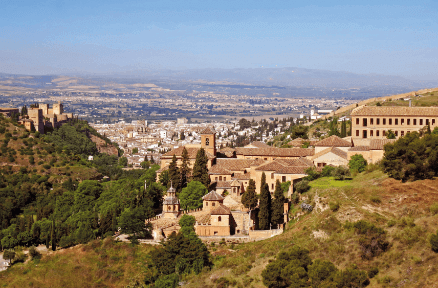 Vistas de la Abadía del Sacromonte con la Alhambra en frente y la ciudad de Granada y la vega de fondo.